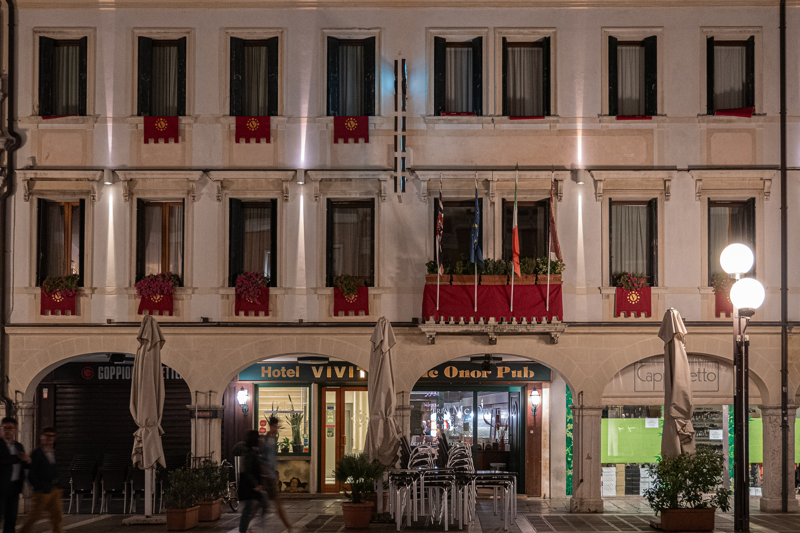 Hotelfassade mit venezianischen Fahnen bei Nacht